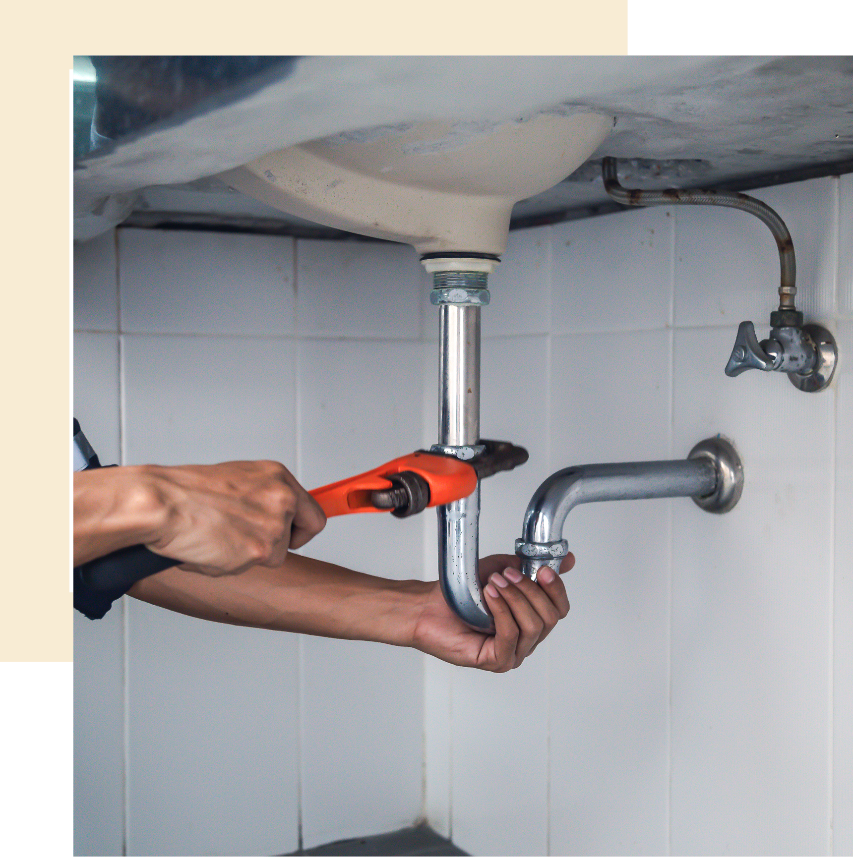 Plumber fixing sink pipe with wrench.