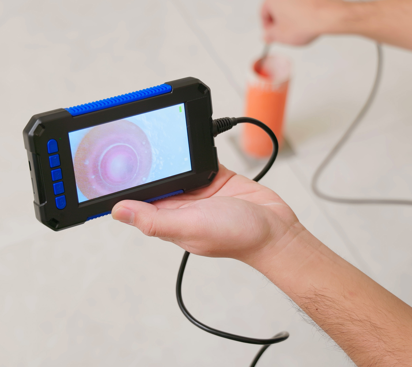 Hand holding a video inspection camera device.